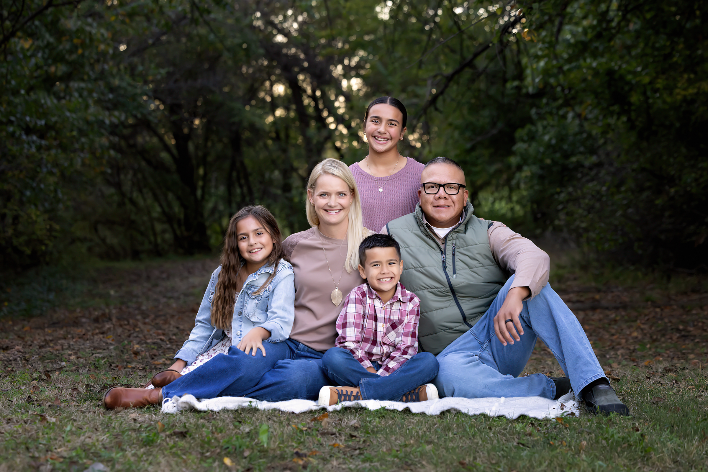 Family of five sitting together outdoors for a family photography session in Wichita, Kansas