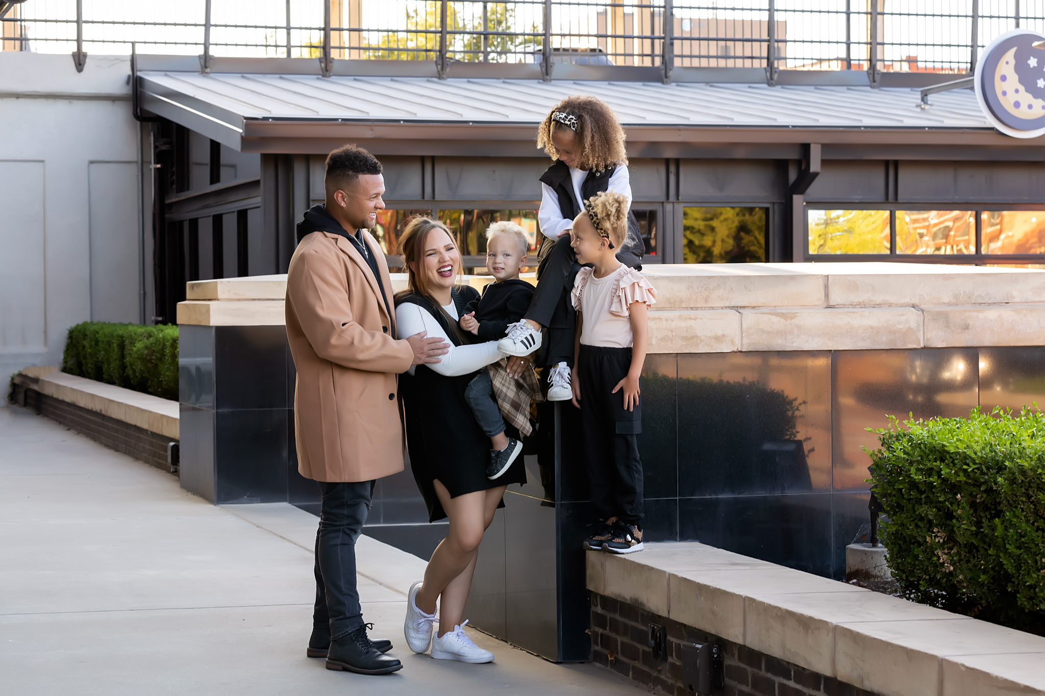 Family posing together outdoors near a modern building