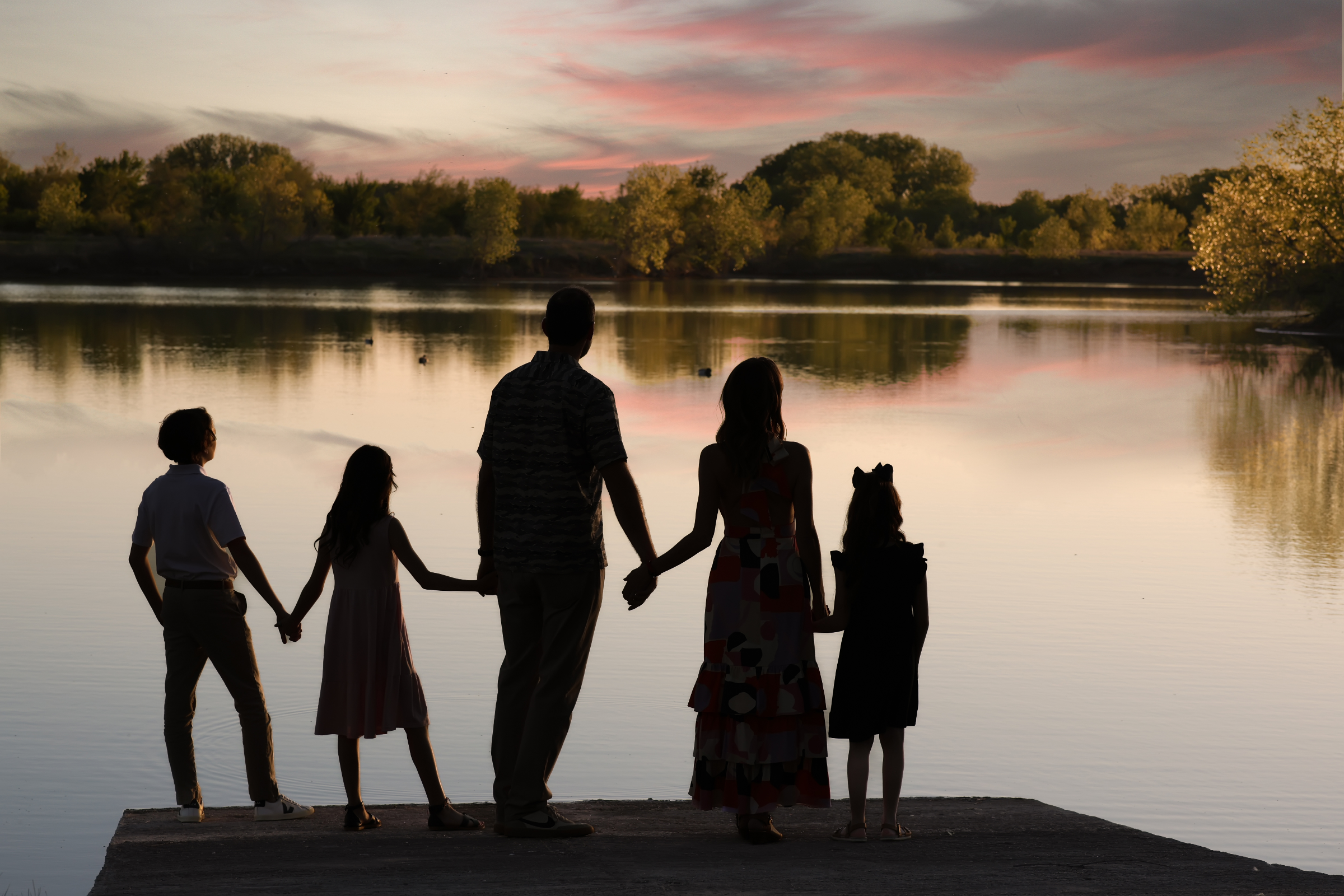 Parents and children sharing a warm family moment outdoors at golden hour