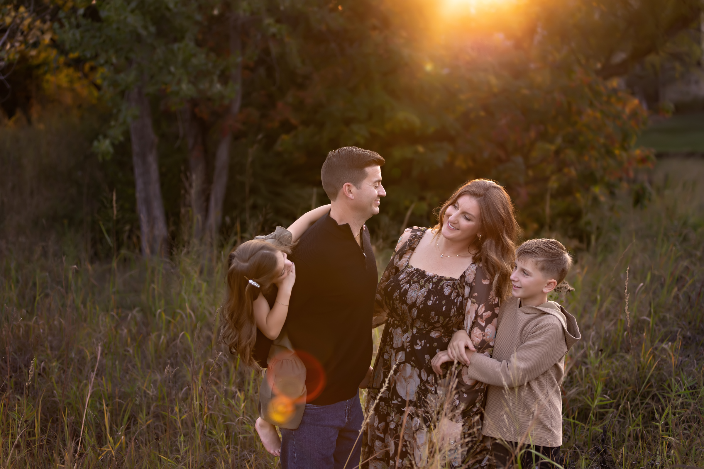 Family holding hands beside a lake at sunset