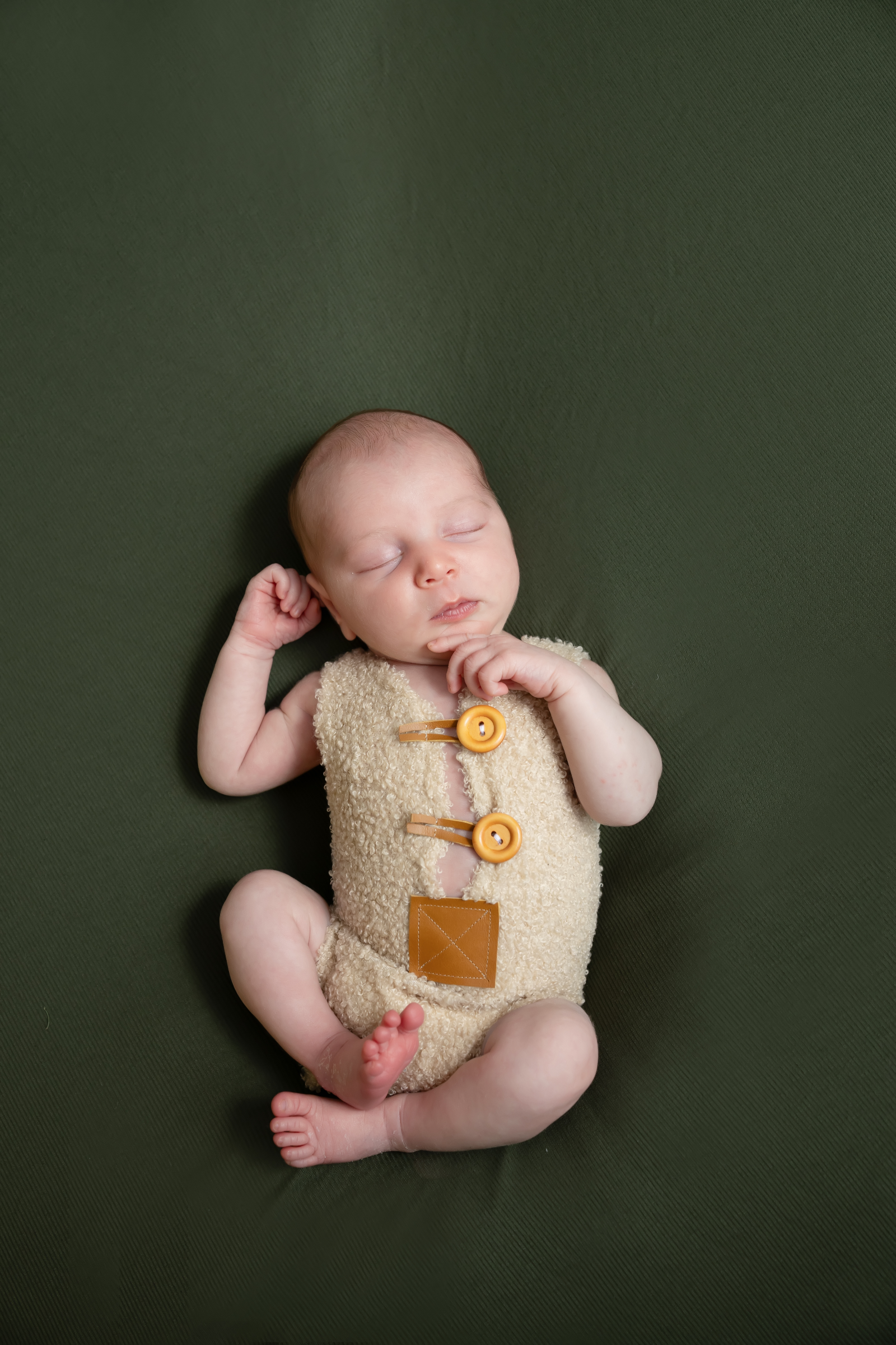 Sleeping newborn wrapped in purple with a pink floral headband